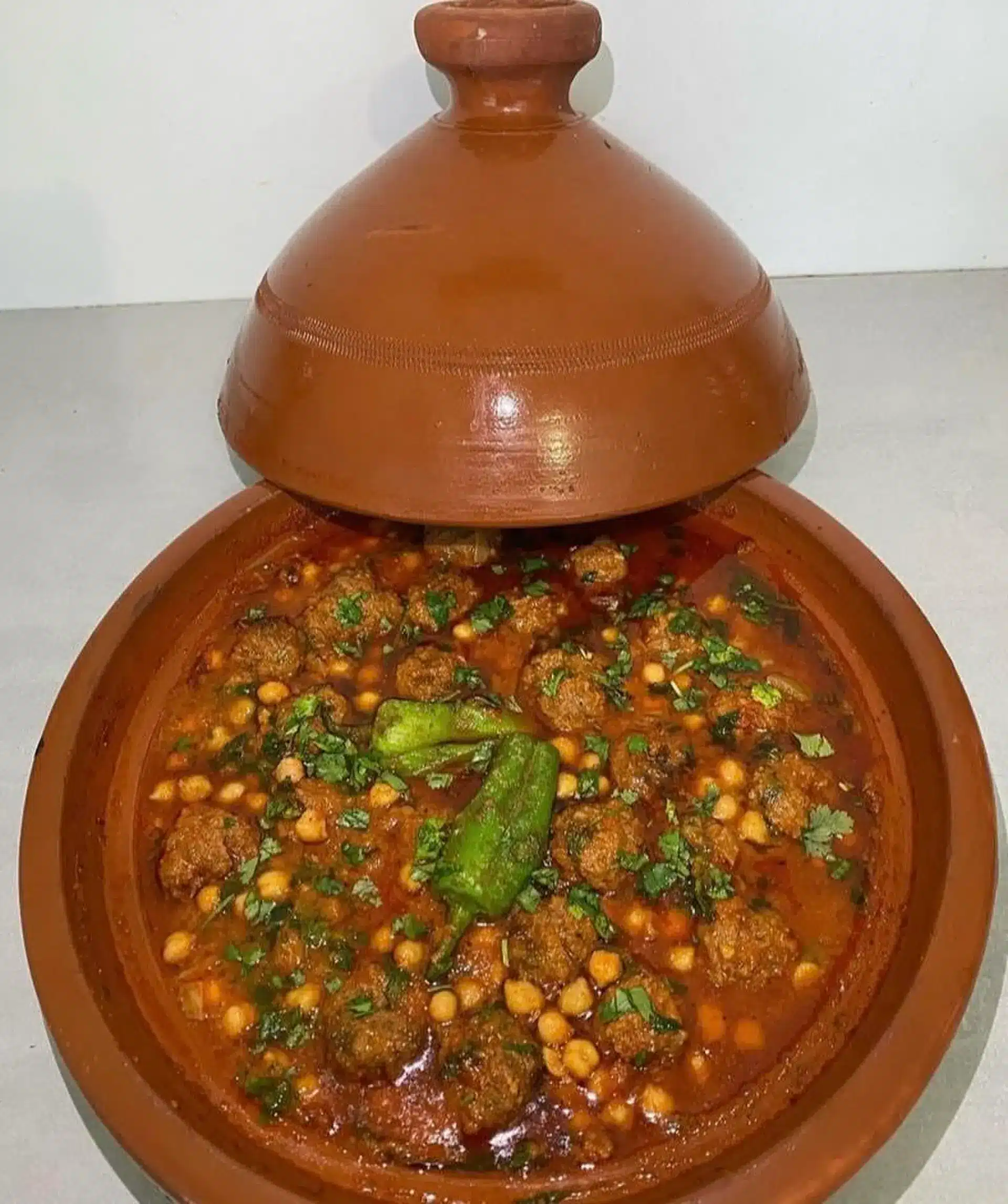 Authentic Algerian Tajine Mtewem with garlic meatballs, chickpeas, and almonds